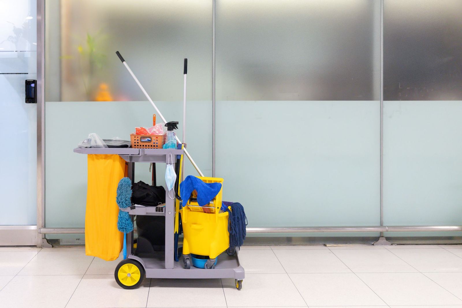 Janitorial cart with mop, bucket, and cleaning supplies